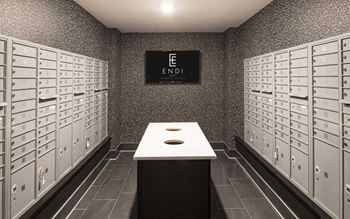 A room with a long table in the middle and a wall of mailboxes on either side.